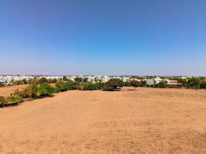 an empty field with a city in the background at HK Inn in Mandvi