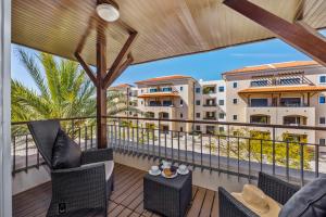 a balcony with chairs and a view of a building at Pine Garden Apartment Vilamoura in Vilamoura