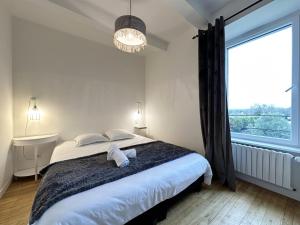 um quarto com uma cama grande e uma janela grande em La Ferme de Kersa em Ploubazlanec