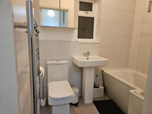een badkamer met toilet, wastafel en ligbad bij Nariken Apartments, Cardiff in Cardiff +15 foto's