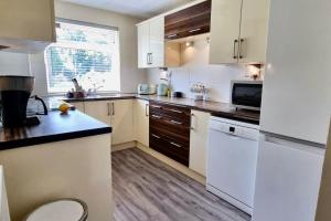 a kitchen with white appliances and wooden floors at King Or Twin Bed In Stylish Home in Nottingham