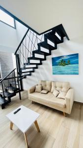 a living room with a couch and a staircase at PH Duplex con Terraza y Asador en Microcentro in Santiago del Estero