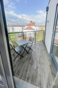 een balkon met een tafel en stoelen op een terras bij Spacious Apt, 2 baths, Balcony, near the O2 Arena in Londen