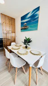 comedor con mesa blanca y sillas en PH Duplex con Terraza y Asador en Microcentro en Santiago del Estero