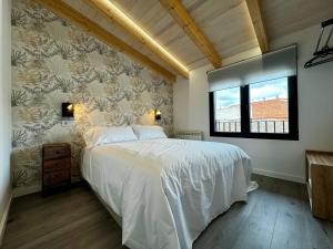a bedroom with a white bed and a window at Apartamentos centro I.II in El Barraco