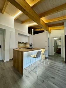 a kitchen with a counter and chairs in a room at Apartamentos centro I.II in El Barraco