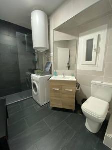 ein Badezimmer mit einem WC, einem Waschbecken und einem Spiegel in der Unterkunft Piso en el corazón de A Coruña. in A Coruña