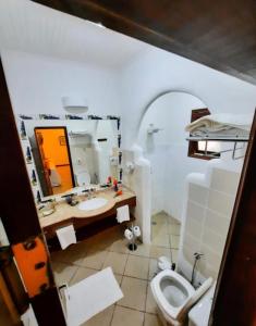 uma casa de banho com um lavatório, um WC e um espelho. em Pousada Villa Cumuru em Cumuruxatiba