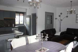 Una cocina y una sala de estar con una mesa y un sofá. en Gite Des 3 Chateaux, en Ribeauvillé