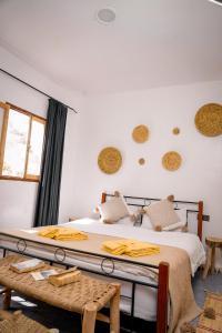 a bedroom with a bed with yellow blankets on it at Soul Surf House in Agadir