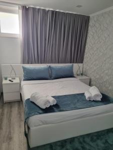 um quarto com uma cama com toalhas em Mikaela Guest House em Odivelas