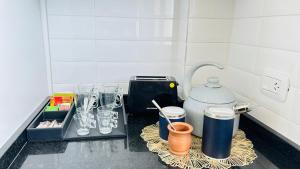 a kitchen counter with glasses and a coffee pot at PH Duplex con Terraza y Asador en Microcentro in Santiago del Estero