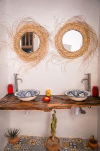 two sinks on a wooden shelf with two mirrors at Soul Surf House in Agadir