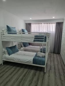sypialnia z 2 łóżkami piętrowymi w pokoju w obiekcie Mikaela Guest House w mieście Odivelas
