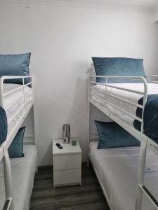 a room with two bunk beds and a night stand at Mikaela Guest House in Odivelas