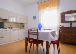 cocina con mesa con sillas y ventana en Dimora Puccini centro storico 600 metri e mare 8km, en San Vito dei Normanni
