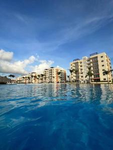 ein großer Wasserkörper mit Gebäuden im Hintergrund in der Unterkunft Relaxing condo near airport PUJ Pool/Wi-fi in Punta Cana