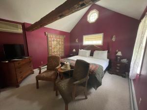 Schlafzimmer mit einem Kingsize-Bett und lila Wänden in der Unterkunft Arlington Inn & Spa in Arlington