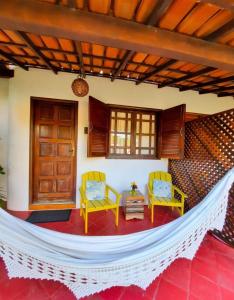 a room with a hammock in a house at Pousada Villa Cumuru in Cumuruxatiba