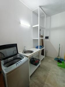 een kleine keuken met een wastafel en een wasmachine bij Appartement Mariquita in Las Terrenas