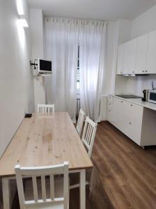 - une cuisine avec une table en bois et des placards blancs dans l'établissement Casa D'aste, à Gênes