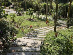 a stone path in the middle of a garden at Wetlands Wayanad Resort with Natural Waterfalls in Padinjarathara