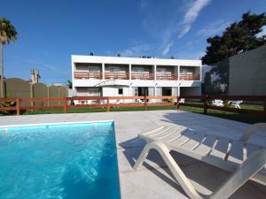 a swimming pool with a chair and a building at Laguna Suites in Miramar
