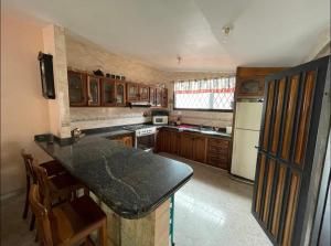 eine Küche mit Holzschränken und einer schwarzen Arbeitsplatte in der Unterkunft Casa en San Cristóbal, urb los naranjos in San Cristóbal
