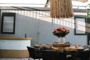una mesa y sillas con un jarrón de flores. en Búho Kite Hotel Boutique, en Salina de Rey