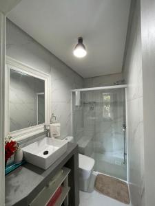 a bathroom with a sink and a shower and a toilet at Kunz Haus Um Refúgio Aconchegante na Natureza! in Nova Petrópolis