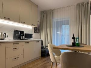 a kitchen and dining room with a table and chairs at City Sense - Brand New Apartment Close to the City Center and Main Station in Wrocław