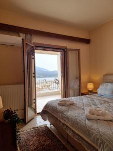 a bedroom with a bed and a view of the ocean at Alexandra's Cozy Sea View Apartment in Argostoli