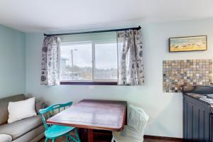 ein Wohnzimmer mit einem Tisch und einem Sofa in der Unterkunft Breakwater Inn - Shoalwater Cottage #E in Grayland