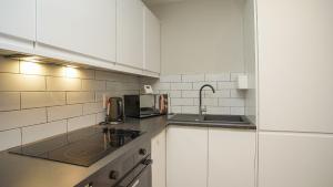 a white kitchen with a sink and a microwave at Luxury 1 BDR City Apartments by Belfast City Breaks in Belfast