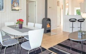 a living room with a white table and a fireplace at Cozy Home In Haderslev With Sauna in Flovt