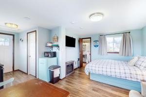 1 dormitorio con paredes azules, 1 cama y 1 mesa en Breakwater Inn - Shoalwater Cottage #E, en Grayland