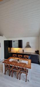 a kitchen with a wooden table and two benches at Lofoten Rorbu - Odin bua in Stamsund