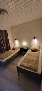 Habitación con 2 camas y mesa con 2 lámparas en Lofoten Rorbu - Odin bua en Stamsund