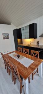 a kitchen with a wooden table with chairs and a counter at Lofoten Rorbu - Odin bua in Stamsund