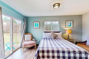 um quarto com uma cama, uma janela e uma cadeira em Breakwater Inn - Zaunder Condo #1 em Grayland