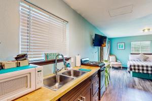 a kitchen with a sink and a microwave at Breakwater Inn - Zaunder Condo #1 in Grayland