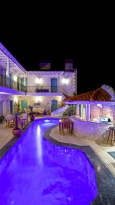 a swimming pool at night with purple lights at Avlu Alaçatı Boutique Hotel in Alacati