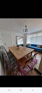 ein Wohnzimmer mit einem Holztisch und Stühlen in der Unterkunft Lovely 3 bedroom house free parking in Luton
