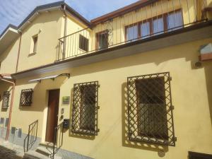 - un bâtiment jaune avec deux fenêtres et un balcon dans l'établissement Coppito Apartment, à Coppito