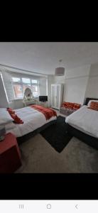 ein großes Schlafzimmer mit 2 Betten und einem Fenster in der Unterkunft Lovely 3 bedroom house free parking in Luton