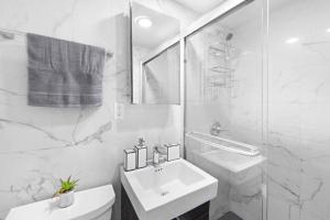 Baño blanco con lavabo y aseo en 69-4B Modern Lower East Side 1BR PRIME LOCATION en Nueva York