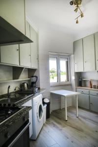 a kitchen with a stove and a washing machine at Alvalade SkyView CoLiving in Lisbon