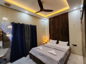 - une chambre avec un lit et un ventilateur de plafond dans l'établissement Lavish inn homestay, à Mysore