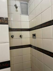 a tiled bathroom with a shower with a window at Conforty and cozy in Rio - Flamengo in Rio de Janeiro