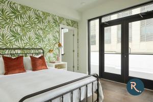 a bedroom with a bed with a green and white wall at Roami at St. Charles in New Orleans